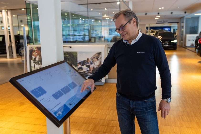 Frank Gjersøe viser hvordan skjermene brukes i butikk.